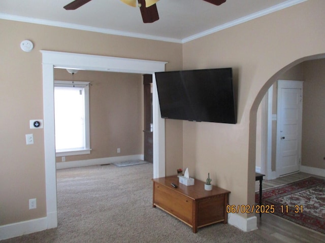 1036 Camp St, Piqua, OH 45356 - living room featuring arched walkways, a ceiling fan, crown molding, baseboards, and carpet