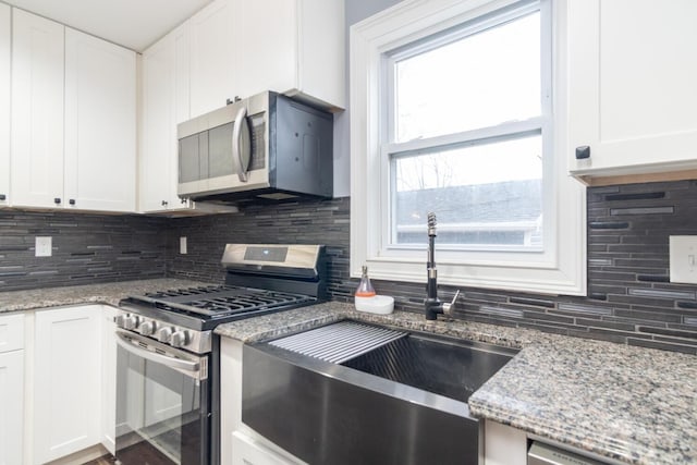 kitchen featuring white cabinetry, stainless steel appliances, sink, and decorative backsplash