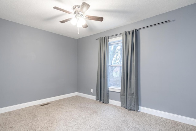 spare room with ceiling fan, light colored carpet, and a textured ceiling