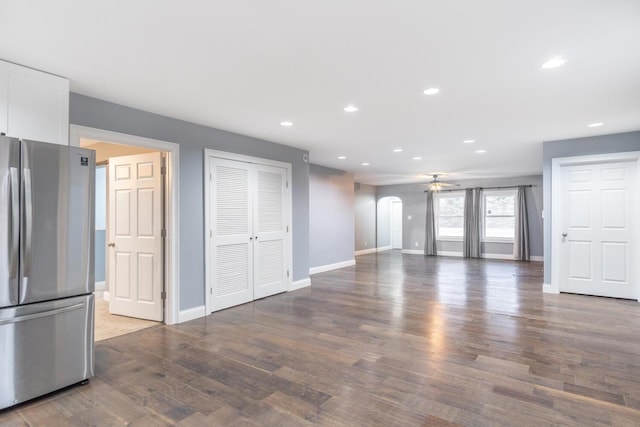 unfurnished living room with ceiling fan and dark hardwood / wood-style flooring