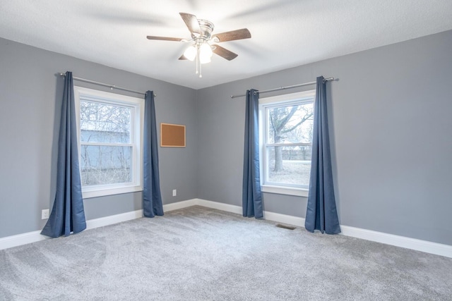 carpeted spare room with ceiling fan