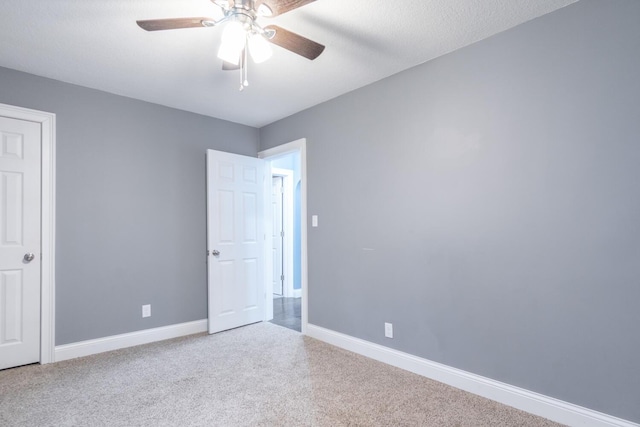 carpeted empty room featuring ceiling fan