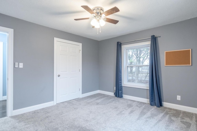 unfurnished bedroom with a textured ceiling, ceiling fan, and carpet flooring