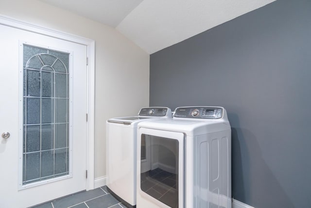 laundry room with dark tile patterned flooring and washing machine and clothes dryer