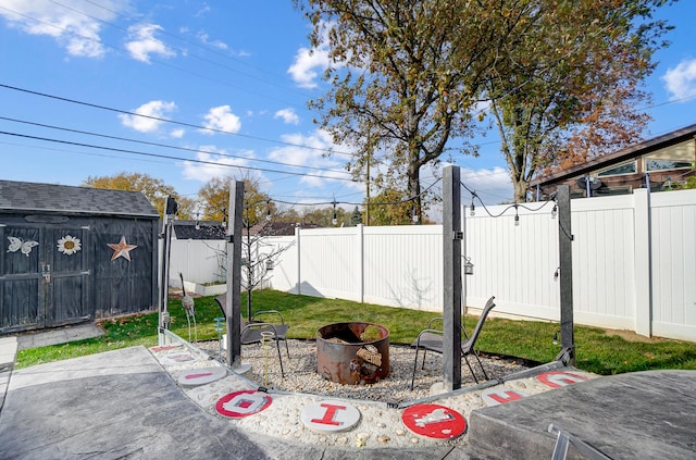 view of patio / terrace with a storage shed and a fire pit