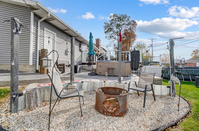 view of patio / terrace featuring a fire pit and a hot tub