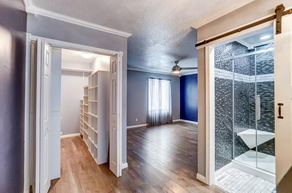 bathroom with crown molding, wood-type flooring, a textured ceiling, and ceiling fan