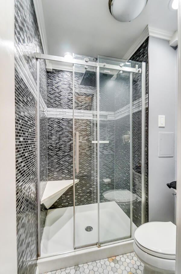 bathroom with walk in shower, toilet, tile patterned flooring, and crown molding