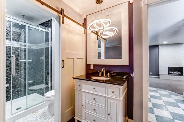 bathroom with vanity, toilet, an enclosed shower, and a brick fireplace