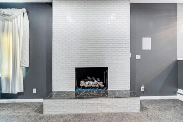 interior details featuring a fireplace and carpet flooring