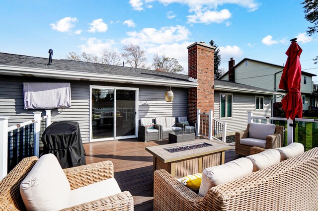 deck with an outdoor living space with a fire pit