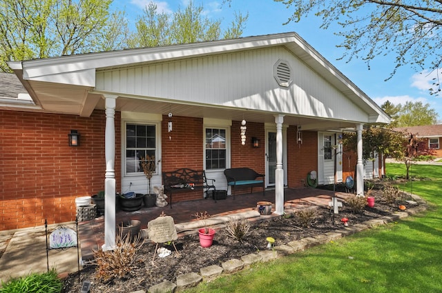 rear view of house with brick siding and a porch