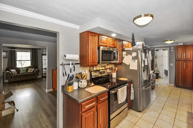 kitchen featuring decorative backsplash, baseboards, ornamental molding, and stainless steel appliances