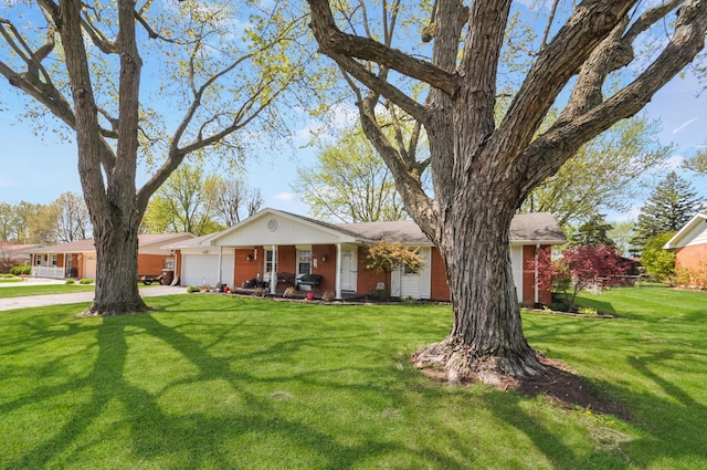 single story home with driveway, a front lawn, brick siding, and a garage