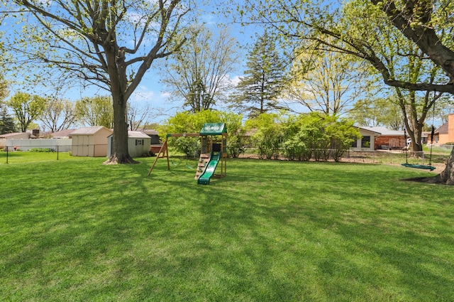 view of yard featuring a storage shed, an outbuilding, a playground, and fence