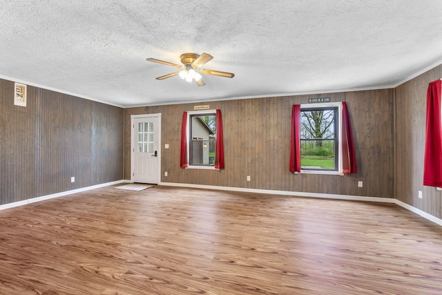 unfurnished living room with baseboards, a ceiling fan, a textured ceiling, and wood finished floors