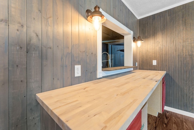 bathroom featuring wooden walls and a textured ceiling