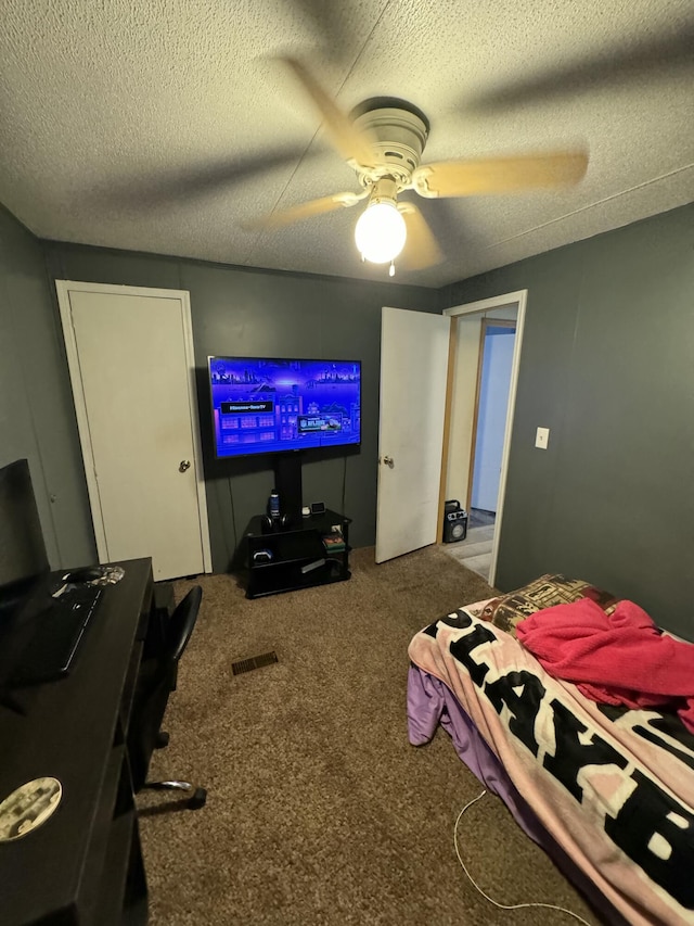 bedroom featuring ceiling fan, a textured ceiling, and carpet flooring