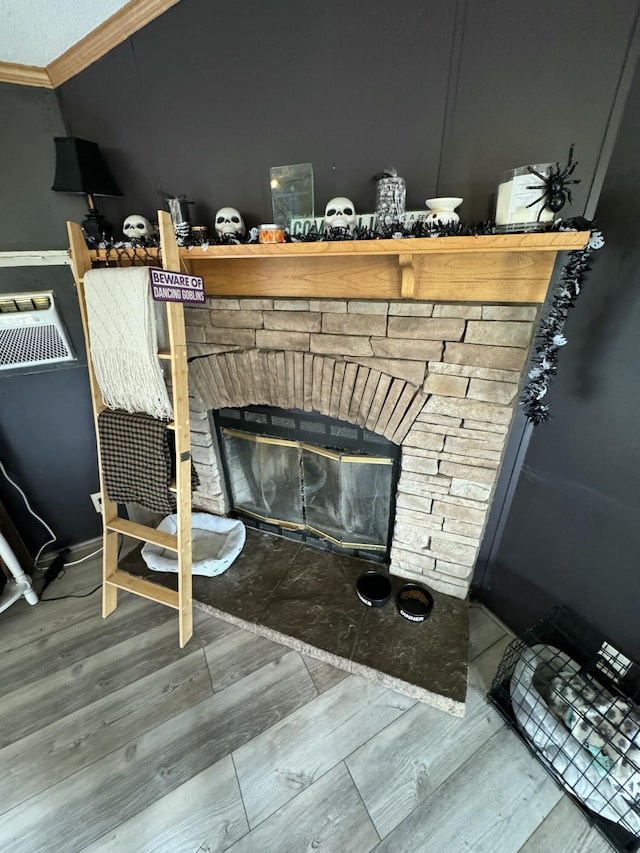 room details with a stone fireplace, wood-type flooring, and ornamental molding