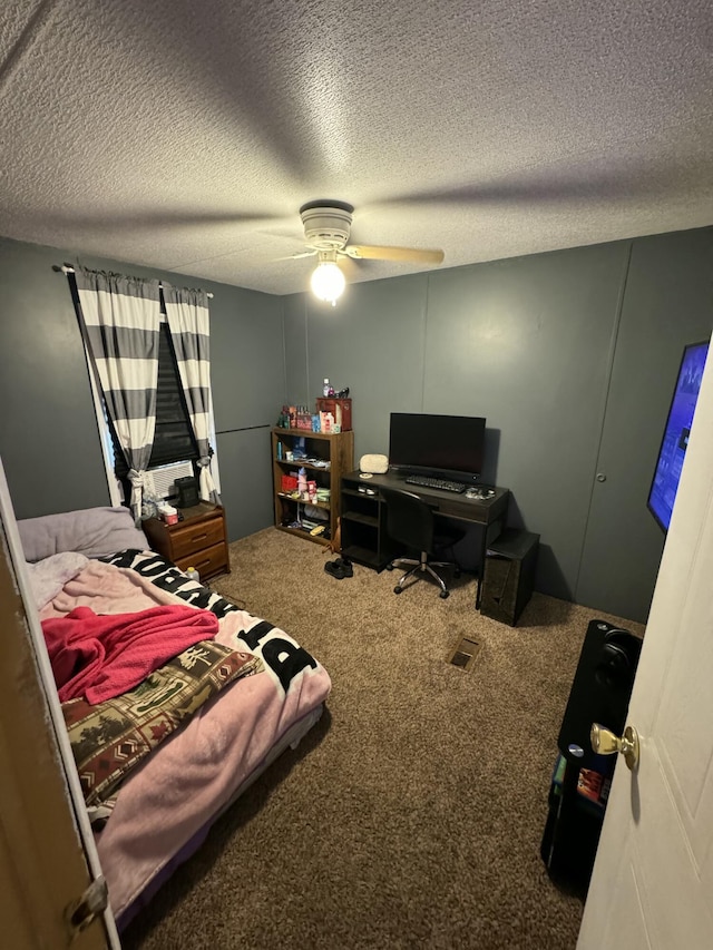 bedroom featuring ceiling fan, carpet floors, and a textured ceiling