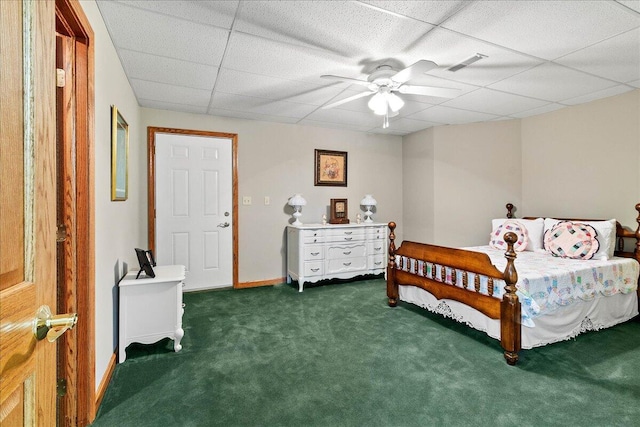 carpeted bedroom with a ceiling fan, a drop ceiling, visible vents, and baseboards