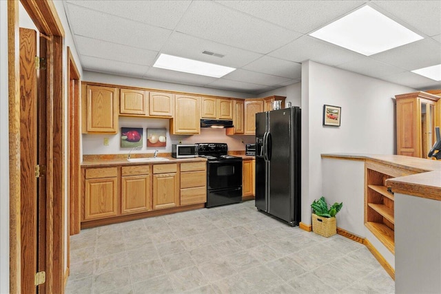 kitchen featuring under cabinet range hood, light countertops, black appliances, open shelves, and a sink