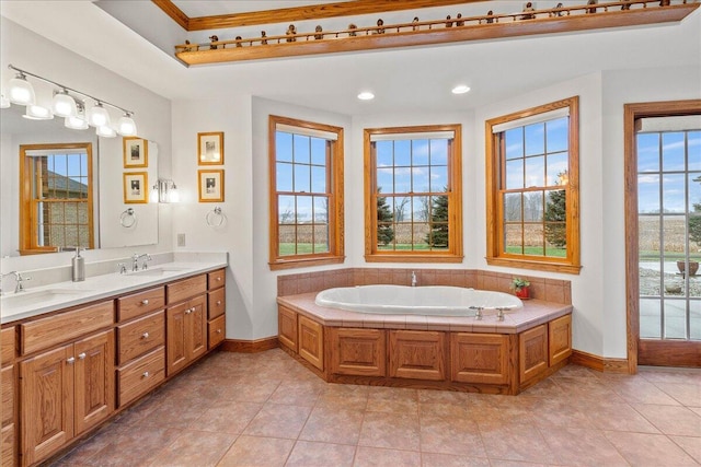 bathroom featuring a garden tub, baseboards, and a sink