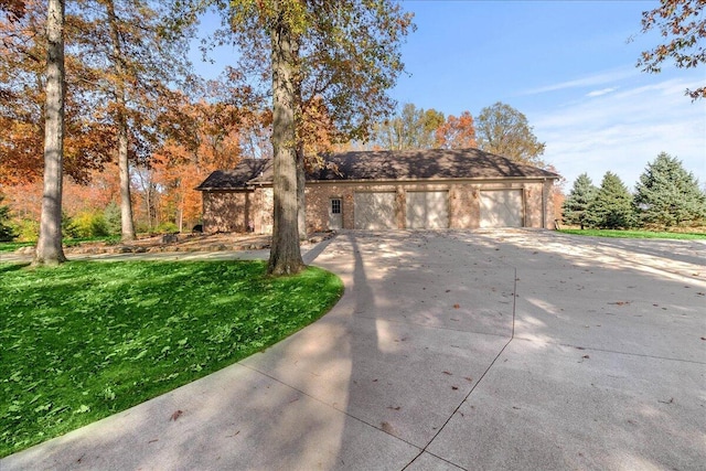 view of front of house with a front yard and a detached garage