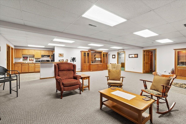 living area featuring light carpet, a paneled ceiling, visible vents, and baseboards