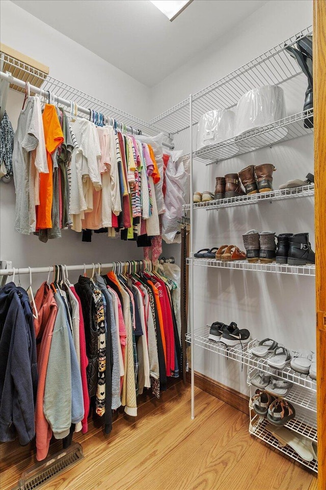 walk in closet with wood finished floors