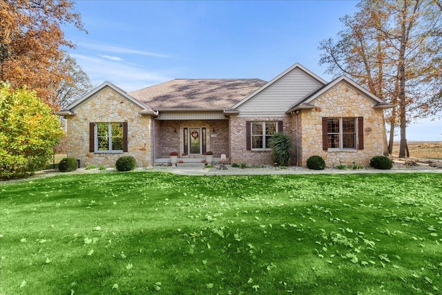 ranch-style house with a shingled roof, a front yard, and brick siding