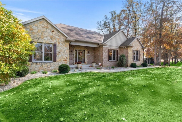 view of front of house with roof with shingles and a front yard