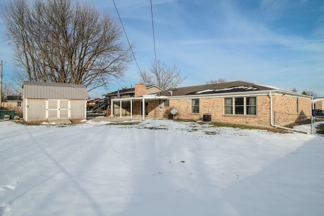 snow covered property with a storage unit