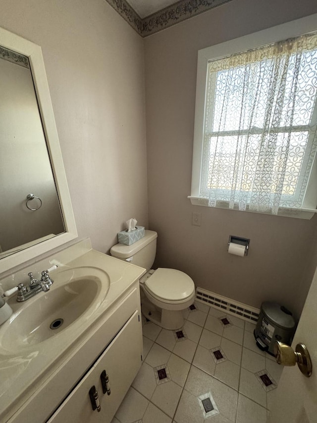 bathroom featuring baseboard heating, tile patterned floors, vanity, and toilet