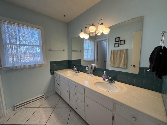 bathroom with tasteful backsplash, vanity, tile patterned floors, and a textured ceiling