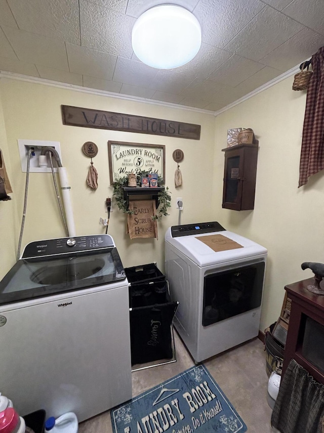 clothes washing area with laundry area, crown molding, and washer and dryer