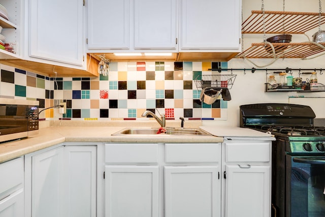 413 Weinland St, New Carlisle, OH 45344 - kitchen featuring black range with gas stovetop, white cabinets, tasteful backsplash, and light countertops