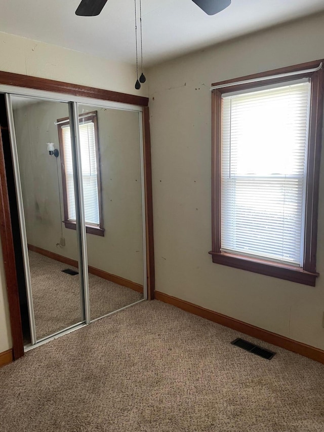 unfurnished bedroom featuring a closet, visible vents, carpet flooring, and baseboards