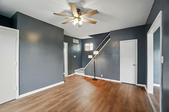 925 E St, Springfield, OH 45505 - empty room with ceiling fan, wood finished floors, baseboards, and stairs