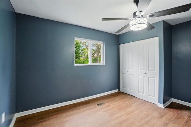 925 E St, Springfield, OH 45505 - unfurnished bedroom featuring wood finished floors, a closet, baseboards, and a ceiling fan
