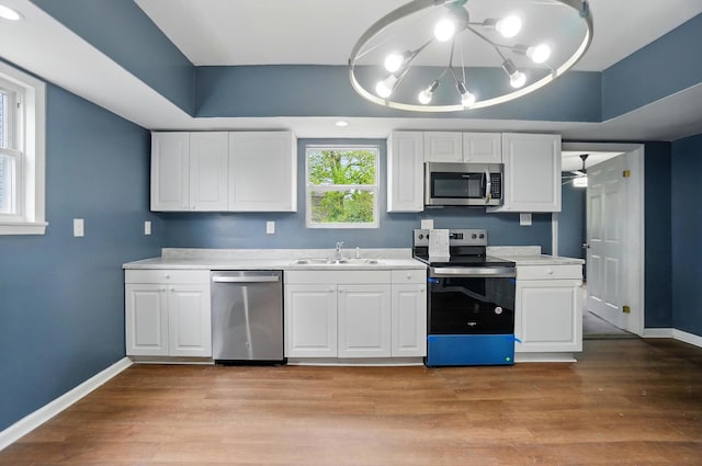 925 E St, Springfield, OH 45505 - kitchen featuring appliances with stainless steel finishes, a sink, baseboards, light countertops, and white cabinetry