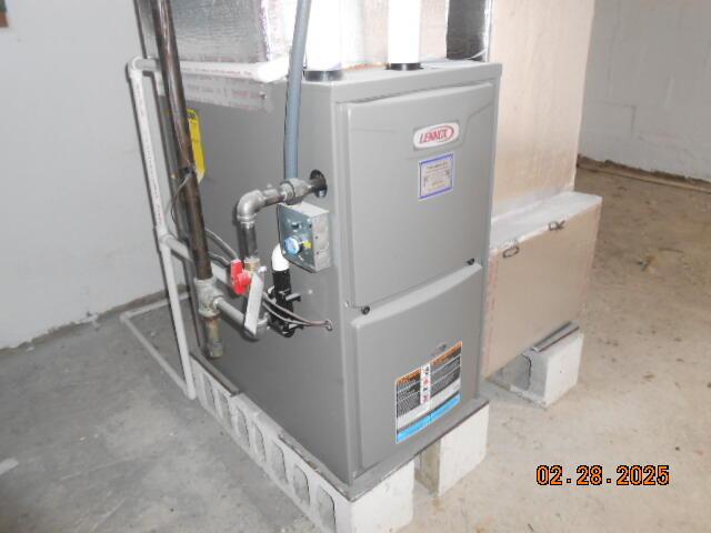 utility room featuring heating unit