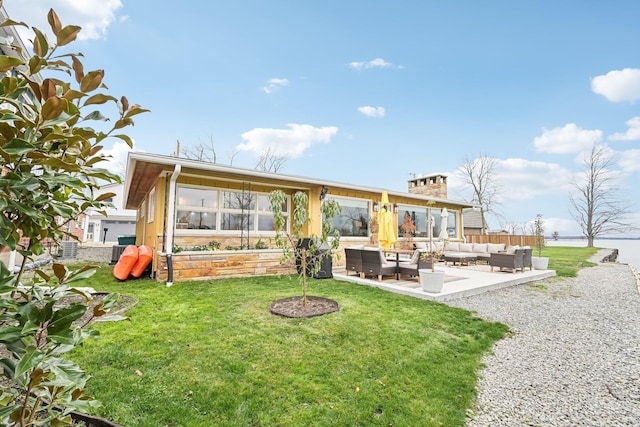 rear view of property featuring cooling unit, a patio, a lawn, and an outdoor hangout area