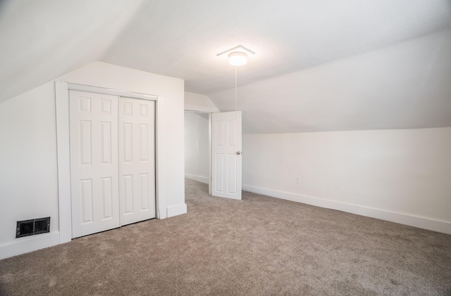 bonus room with carpet floors, visible vents, and lofted ceiling