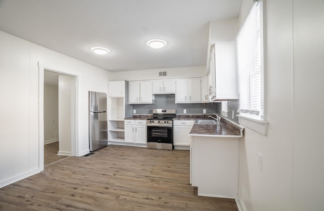 kitchen with stainless steel appliances, visible vents, a sink, and dark wood-type flooring