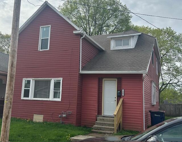 view of front of home with roof with shingles, fence, and entry steps