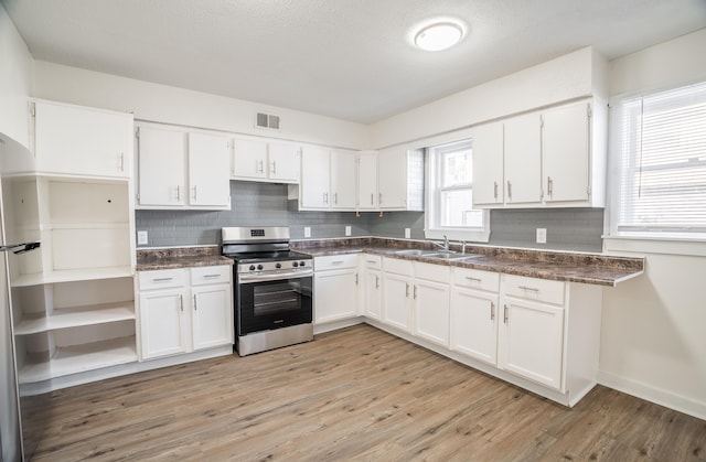 kitchen featuring visible vents, a sink, appliances with stainless steel finishes, and dark countertops