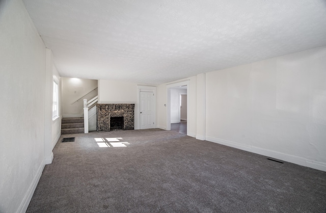 unfurnished living room with carpet floors, baseboards, stairs, and visible vents