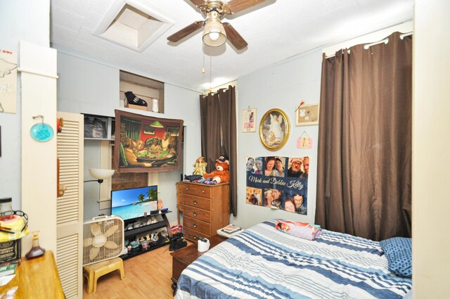 bedroom featuring attic access, ceiling fan, and wood finished floors