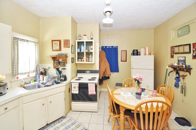 kitchen with light tile patterned flooring, white appliances, light countertops, and a sink